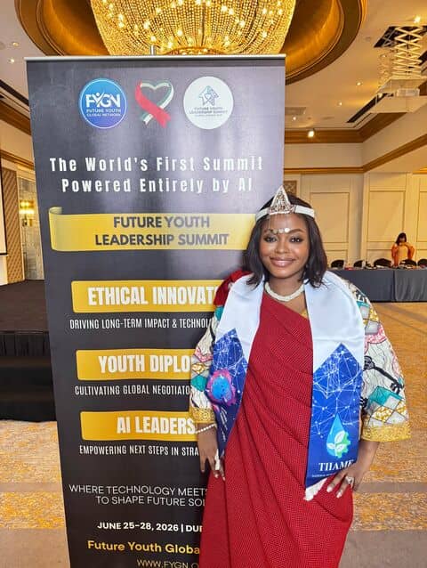 A delegate in traditional dress in front of the summit banner in Dubai.