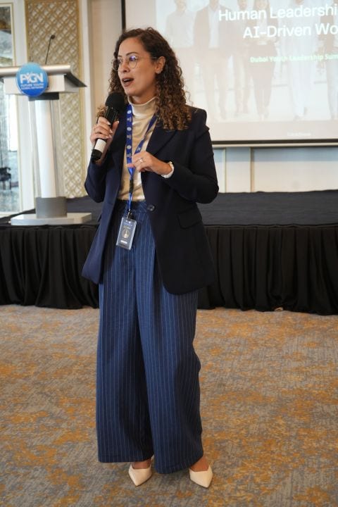A delegate speaking into a microphone during a summit session.