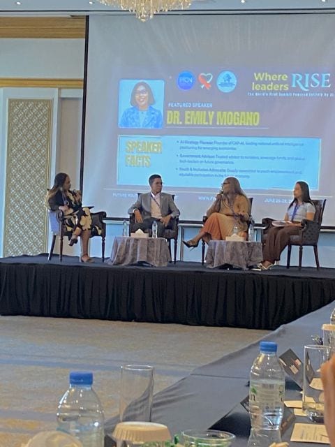 A panel discussion at the summit with the speaker's name shown on screen.